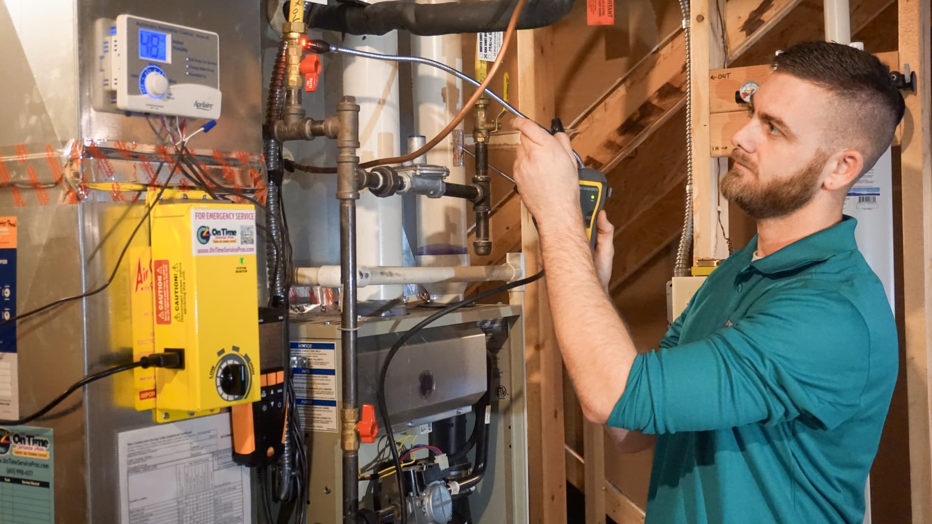 On Time Service Pros heating technician inspecting a furnace with a gas leak detector
